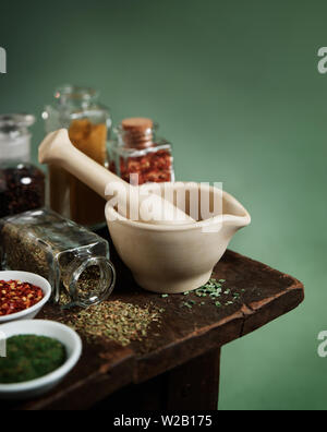 Vintage mortier et pilon avec épices et herbes sur table en bois Banque D'Images