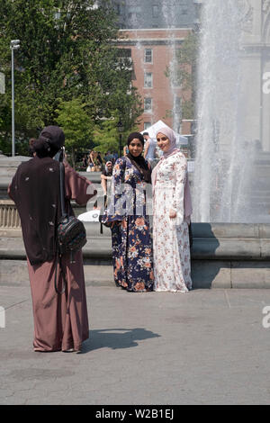 Deux femmes musulmanes dans un hijab longues posent pour une photo touristique près de la fontaine à Washington Square Park à Greenwich Village, New York City. Banque D'Images