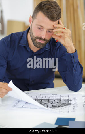 Ingénieur est de travailler sur le bureau avec plan de dessin Banque D'Images