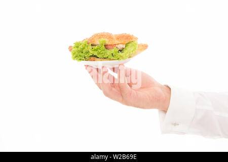 Les Calories et les régimes amaigrissants. Main de garçon porter la plaque avec le plat. De délicieux croissants. Servant un croissant farci de laitues et légumes frais. Cafe concept. Alimentation saine. Croissant traditionnel français. Banque D'Images