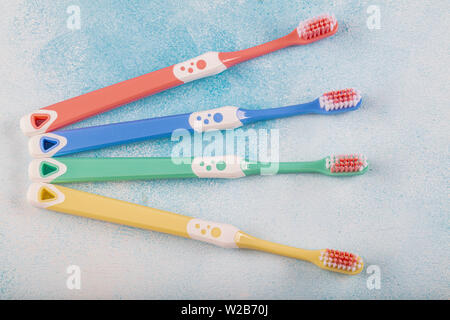 Brosse à dents en quatre morceaux, couleur bleu sur fond de bois. Banque D'Images
