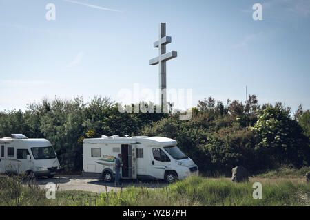 Deux véhicules récréatifs (VR) garé juste derrière la Croix de Lorraine, en Graye-Sur-Mer  un homme monter dans un le RV peut être vu Banque D'Images