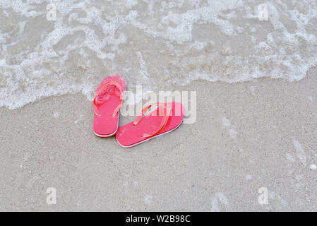 Tongs sur la plage avec des vagues à la plage de sable de mer océan - Vue de dessus Banque D'Images