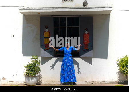 Une belle jeune femme indienne modèle dans une robe bleue s'amusant et posant devant la fenêtre d'un café avec des Chinois d'art graffiti sur le mur. Banque D'Images