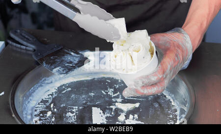 Incorporer la crème glacée frite-rouleaux à geler la casserole. Faire de la crème glacée laminées, part de la création d'un dessert. La crème glacée frite machine avec steel pan réfrigérés. Banque D'Images