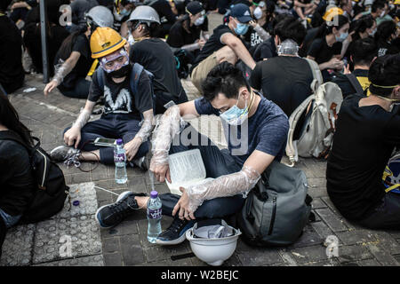 Manifestant lit assis sur le sol devant le Conseil législatif de Hong Kong au cours de construction manifestation contre la loi sur l'extradition vers la Chine Banque D'Images