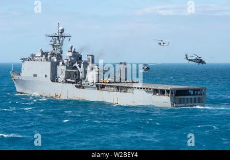 190707-N-DX072-1128 CORAL SEA (7 juillet 2019) Un hélicoptère Huey UH-1Y, affecté à la 31e Marine Expeditionary Unit (MEU) « Dragons' du milieu marin de l'escadron à rotors basculants (VMM) 265 (renforcée), MH-60S et deux hélicoptères Sea Hawk, attribué à l'île "Chevaliers" de la mer de l'Escadron d'hélicoptères de combat (HSC) 25, passez près du quai de débarquement amphibie USS Ashland (LSD 48) lors d'une visite, un conseil, une perquisition et saisie (VBSS) foret au quai de transport amphibie USS Green Bay (LPD 20). Green Bay et Ashland, partie de la Guêpe groupe amphibie, à 31e MEU, fonctionnent dans l'I Banque D'Images