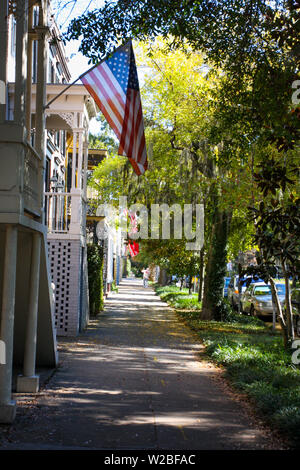 Rue bordée d'arbres et d'un drapeau dans le quartier historique de Savannah, Géorgie. Banque D'Images