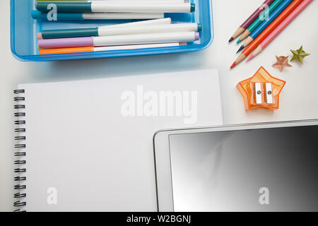 Fournitures pour l'école élémentaire avec un blank notepad et tablette écran tactile. Banque D'Images