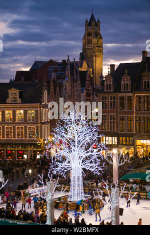 Belgique, Bruges, le Markt, la place principale de bâtiments et d'hiver patinoire, dusk Banque D'Images