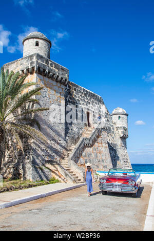 Jeune femme et d'un 1959 Dodge Custom Convertible Lancer fidèles, Cojimar Fort, La Havane, Cuba (MR) Banque D'Images