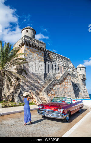 Jeune femme et d'un 1959 Dodge Custom Convertible Lancer fidèles, Cojimar Fort, La Havane, Cuba (MR) Banque D'Images