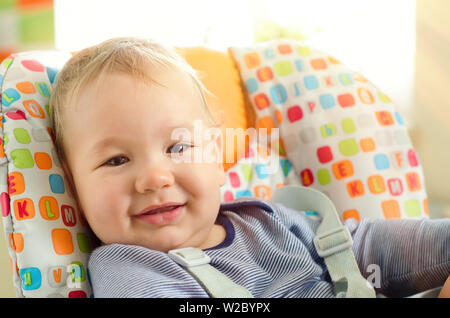 Smiling baby garçon assis dans la chaise haute Banque D'Images