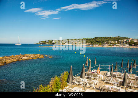 Plage à Antibes (Cap Antibes en arrière-plan), Alpes-Maritimes, Provence-Alpes-Côte d'Azur, d'Azur, France Banque D'Images