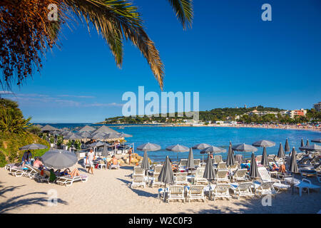 Plage à Antibes (Cap Antibes en arrière-plan), Alpes-Maritimes, Provence-Alpes-Côte d'Azur, d'Azur, France Banque D'Images