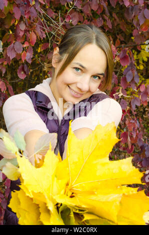 Femme avec bouquet de feuilles jaunes Banque D'Images