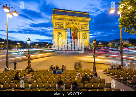 Arc de Triomphe avec le drapeau tricolore français, éclairé au crépuscule, Paris, France Banque D'Images