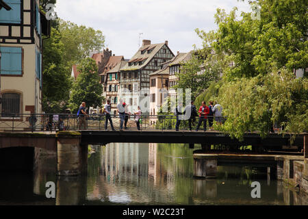 Touristes traversant l'un des nombreux ponts de Petite France, Strasbourg, France Banque D'Images
