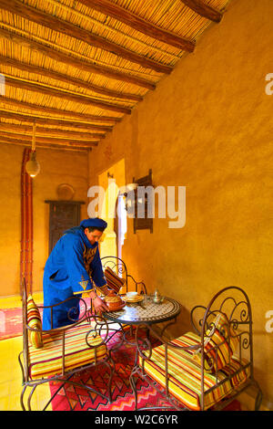 L'homme en costume berbère berbère servant un tajine, Merzouga, Maroc, Afrique du Nord (M.) Banque D'Images