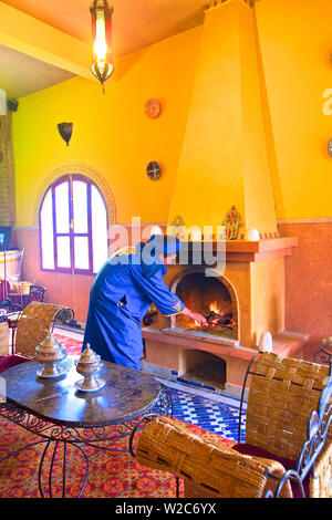 L'homme en costume berbère berbère alimenter le feu, Merzouga, Maroc, Afrique du Nord (M.) Banque D'Images