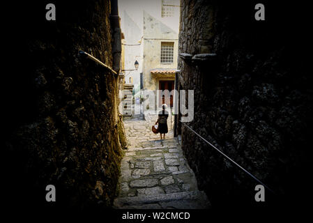 Sartene, Corse, France. Une femme marche dans une ruelle. Photo : © Simon Grosset. Archive : image numérisé à partir d'un original de la transparence. Banque D'Images