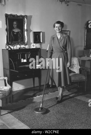 Journée de nettoyage dans les années 1950. Une femme au foyer est la démonstration de la dernière version de l'appareil de nettoyage pour nettoyer les tapis. Suède 1950 Banque D'Images