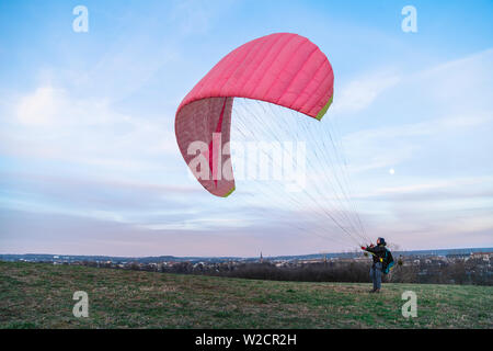 L'homme détient en vol parapente rose plein air du vent Banque D'Images