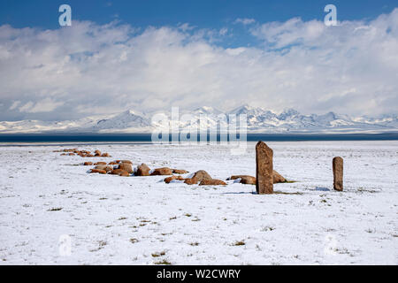 Pierres mémorables traditionnels sur la rive du lac Son-Kul sur l'arrière-plan de montagnes couvertes de neige. Un voyage au Kirghizistan. Banque D'Images