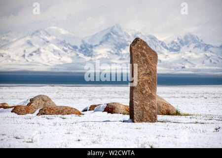 Pierres mémorables traditionnels sur la rive du lac Son-Kul sur l'arrière-plan de montagnes couvertes de neige. Un voyage au Kirghizistan. Banque D'Images