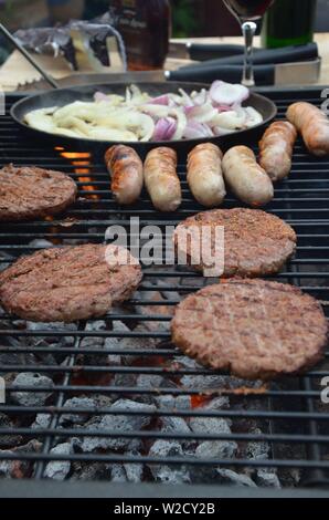 Saucisses et burgers de boeuf cuisson sur le barbecue Banque D'Images