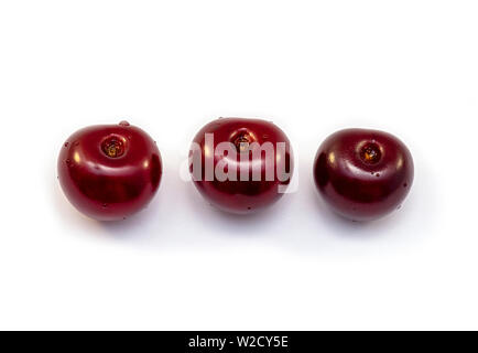 Trois cerises rouge isolé sur fond blanc Banque D'Images