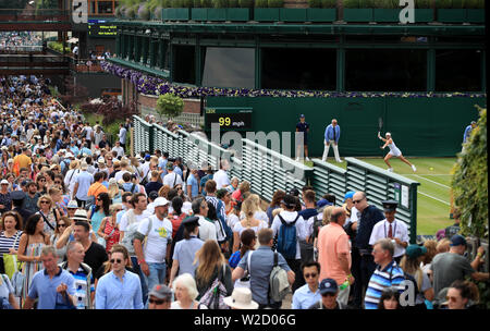 Les spectateurs font leur chemin cour passé dix-huit jours sur sept des championnats de Wimbledon à l'All England Lawn Tennis et croquet Club, Wimbledon. Banque D'Images