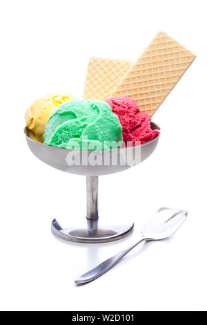 Coupe de glaces : Fraise pistache et boules de glace vanille dans une tasse de métal avec une cuillère et isolé sur fond blanc Banque D'Images
