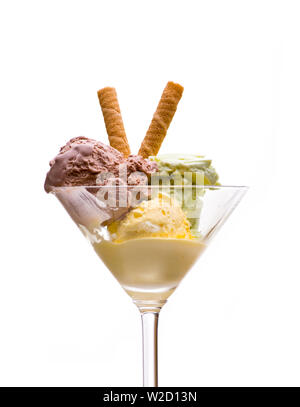 Coupe de glaces : Vue de face de la crème glacée avec du jaune, vert et marron avec de la crème glacée dans un verre à martini sur fond blanc Banque D'Images