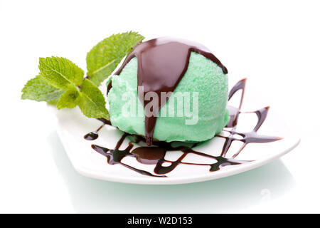 Coupe de glaces : une boule de glace à la menthe surmonté de sauce au chocolat sur fond blanc Banque D'Images