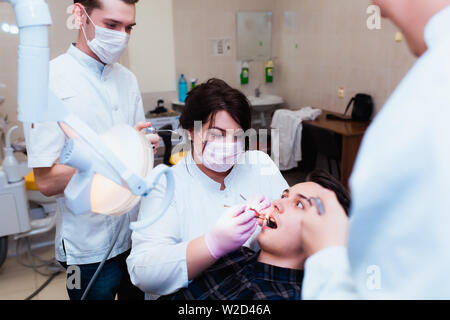 L'Université de médecine. Médecin Dentiste enseignant professionnel traite les dents pour le patient dans le bureau pour l'équipement moderne. Le concept de la formation médicale Banque D'Images