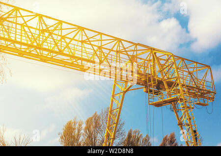 Grue jaune derrière les arbres sur le territoire de l'entreprise. L'industrie, de la production, de l'entrepôt. Banque D'Images