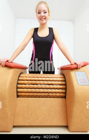 Soin de bien-être, concept. Femme de se débarrasser de la cellulite sur les cuisses grande machine à rouleaux. Massage spa à sain Banque D'Images