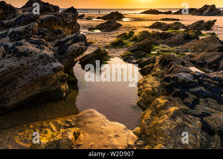 Piscines de roches au coucher du soleil sur la plage de Fistral à Newquay en Cornouailles. Banque D'Images