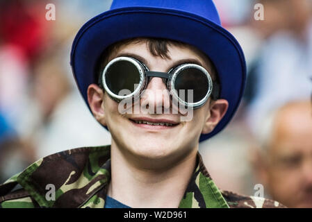 Un adolescent garçon portant des lunettes steampunk et un haut bleu hat. Banque D'Images