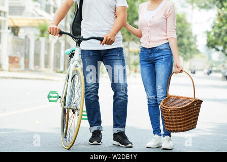 Close-up of young woman in casual clothing debout sur la rue avec location et avec panier pique-nique pour Banque D'Images