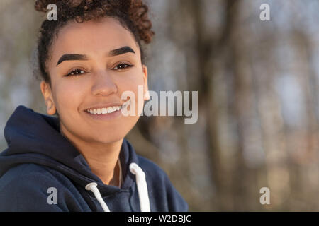 Portrait plein air de belle happy mixed race African American girl biracial adolescent femme jeune femme souriante avec dents parfait bleu portant un ho Banque D'Images