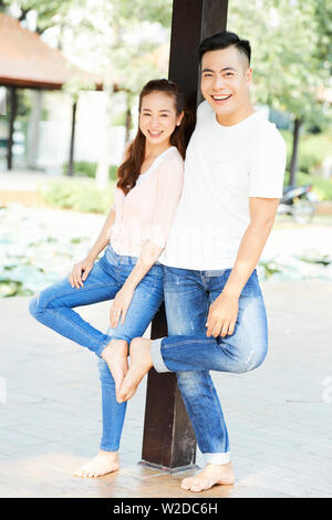 Portrait of happy Young Asian Woman in white T-shirts et jeans en souriant et posant à l'extérieur de l'appareil photo Banque D'Images