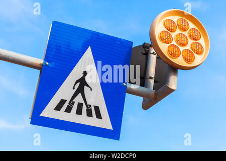 Passage pour piétons. Signe de route et les feux d'avertissement jaune sur fond de ciel bleu Banque D'Images