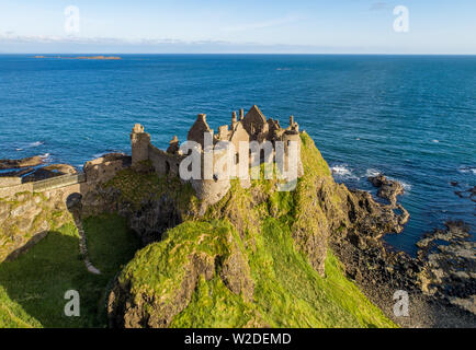 Ruines du château de Dunluce médiévale sur une falaise abrupte. Côte nord du comté d'Antrim, Irlande du Nord, Royaume-Uni. Vue aérienne dans la région de sunrise light Banque D'Images