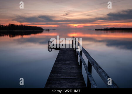 Coucher de soleil sur un lac calme avec jetée en bois, Nord de l'Allemagne Schleswig-Holstein Selent Banque D'Images