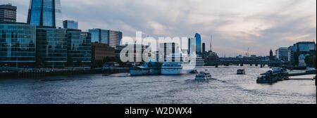 Londres, Royaume-Uni - 22 juin 2019 : vue panoramique de grande maison de bateau de croisière amarré sur la Tamise par HM Belfast pendant l'heure bleue. Londres est l'un des mo Banque D'Images