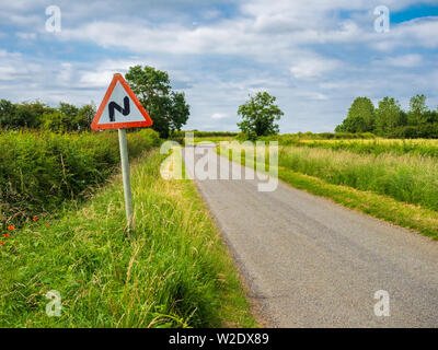 Route sinueuse à venir signer en zig-zag sur le côté d'une seule piste country road Banque D'Images