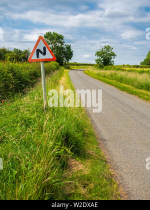 Route sinueuse à venir signer en zig-zag sur le côté d'une seule piste country road Banque D'Images