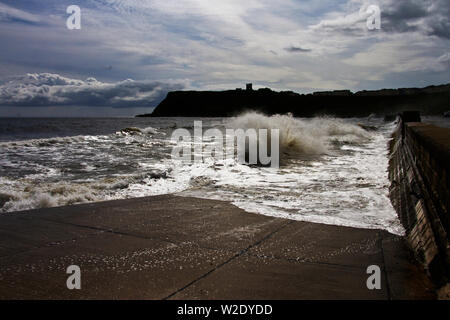 Un vent du nord soulève bientôt les vagues le long du front de mer sur la baie nord de Scarborough sur une journée d'étés frais. Banque D'Images